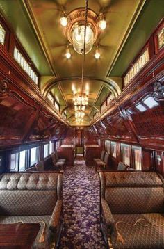 the inside of an old train car with couches and chandeliers