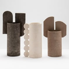 three different shapes and sizes of vases on a white surface with one in the middle