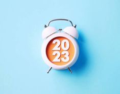 an orange and white alarm clock on a blue background with the numbers twenty two three