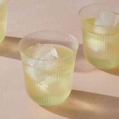 three glasses filled with ice sitting on top of a table