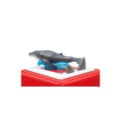 a toy whale on top of a red box