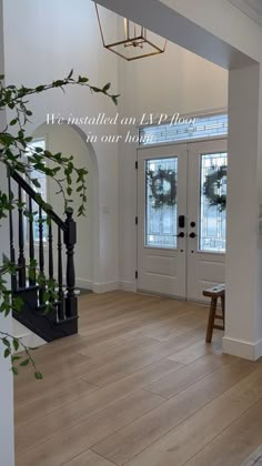 an entryway with wooden floors and white walls