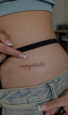 a woman's stomach with the word impossible tattooed on her lower side ribcage