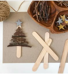 popsicle christmas tree and star decorations on a piece of brown paper next to twine spools