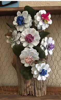 some flowers are sitting in a vase on a shelf