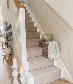 the stairs in this home are decorated with candles and blankets, along with two wicker baskets