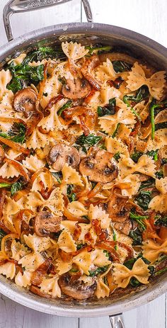 a pan filled with pasta and spinach covered in sauce