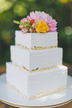 a white wedding cake with flowers on top is featured in the instagram page for this post