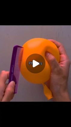 a person is holding an orange comb in their hand