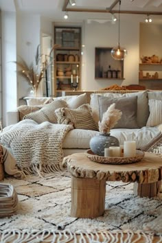 a living room filled with lots of furniture and pillows on top of a white rug