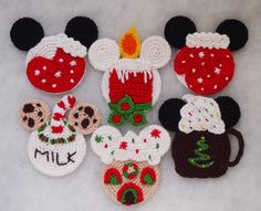 crocheted mickey mouses and other holiday decorations are arranged on a white surface