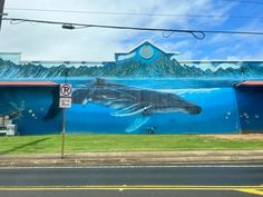 a mural on the side of a building with a whale painted on it's side