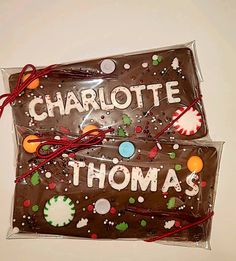 two pieces of chocolate with the words charlotte and thomas written on each side, wrapped in cellophane