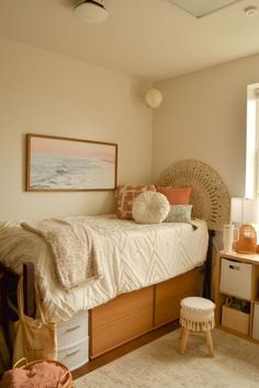 a bedroom with a bed, dresser and window in the corner next to an ottoman