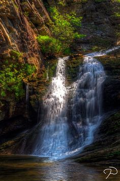 a small waterfall in the middle of a forest