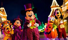 mickey's halloween parade at disney world with goofy, pluto and other characters in costume