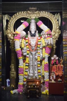 the statue is decorated with flowers and garlands