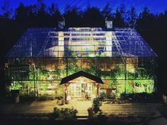 a large glass house lit up at night