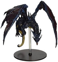 a blue and black dragon figurine on a metal stand with its wings spread