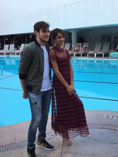 a man standing next to a woman near a swimming pool