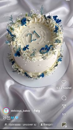 a white cake with blue and white flowers on it's side is displayed for the camera