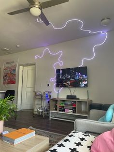 a living room filled with furniture and a flat screen tv mounted on the wall above it