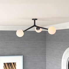 three lights are hanging from the ceiling in a room with grey walls and white trim