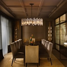 an elegant dining room with chandelier and glass vases on the table in front of it