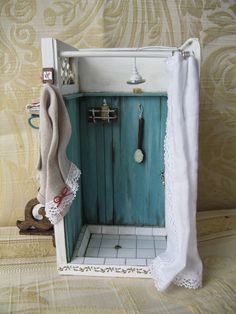 a dollhouse bathroom with an old fashioned sink and towel rack on the wall above it