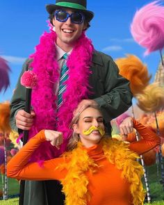 a man and woman with fake mustaches on their heads in front of colorful decorations