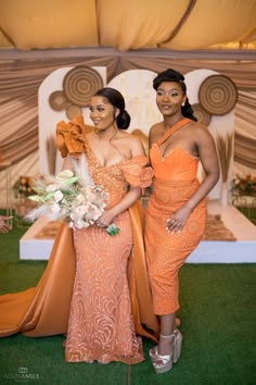 two women in orange dresses standing next to each other