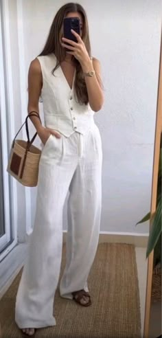 White vest and pants set with dark leather sandals and a basket bag for a purse. Summer outfits, travel outfits, outfits for hot weather, work outfits.  Follow my shop @maggierussell1 on the @shop.LTK app to shop this post and get my exclusive app-only content!  #liketkit #LTKstyletip #LTKworkwear #LTKtravel @shop.ltk   fashion inspo | fashion outfits | fashion aesthetic | outfit ideas | clothes for women | luxury aesthetic | minimalist | chic | old money aesthetic | coastal granddaughter | vacation outfits | European outfits | clothing pictures | young adult style | blazer outfit | linen outfit | pearls | necklace | revolve | fashion icon | fashion design | clothes design | clean girl aesthetic | fashion blogger | summer day outfit | outfit | summer 2024 fashion | nighttime outfits | eleg Europe Outfits, Elegante Casual, Vest Outfits, Summer Fashion Outfits, White Pants