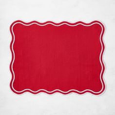 a red place mat with white trim around it on a white tablecloth, ready to be used as a placemat