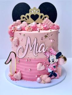 a minnie mouse cake is decorated with pink frosting and gold decorations, including a princess's name