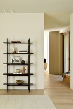 a living room filled with furniture and a book shelf next to a doorway that leads to another room