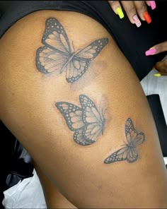 three butterflies on the back of a woman's thigh