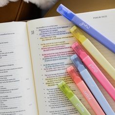 four pens sitting on top of an open book