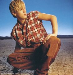 a young man squatting in the desert