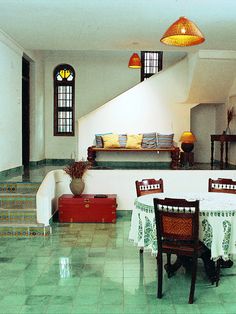 a dining room with green tile flooring and white walls