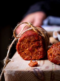 two pieces of food sitting on top of a piece of wood next to a string