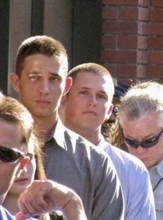 a group of people standing next to each other in front of a brick building with sunglasses on