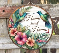 a wooden sign that says home sweet home with two hummingbirds and flowers on it