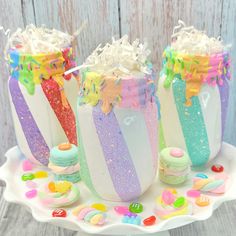 three jars filled with candy and sprinkles on top of a white plate