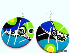 a pair of earrings that are painted with different colors and designs on them, sitting next to each other