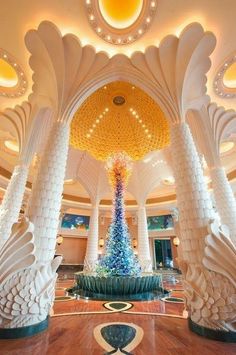 an elaborately decorated lobby with columns and a christmas tree