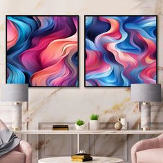 two paintings on the wall in a living room with pink chairs and a coffee table