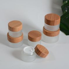 three jars with wooden lids are sitting next to each other