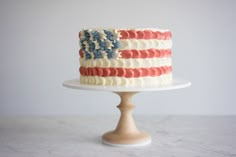 an american flag cake with white frosting and red, white, and blue icing