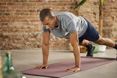 a man doing push ups on a yoga mat