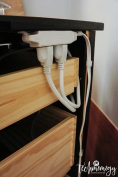 an electric outlet is plugged in to the wall with two white cords connected to it